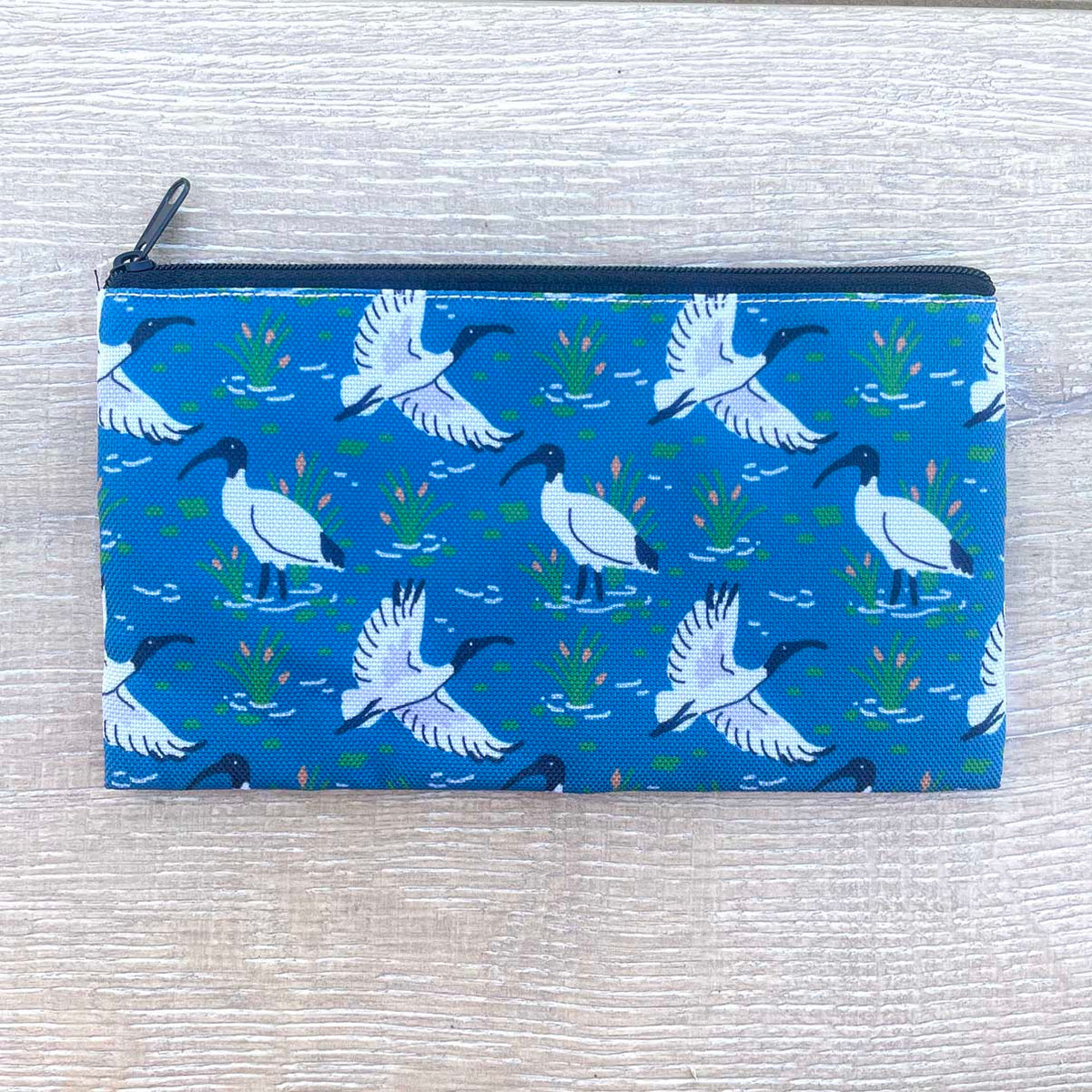 Australian White Ibis wetland pattern pencil case on blue fabric with black zip
