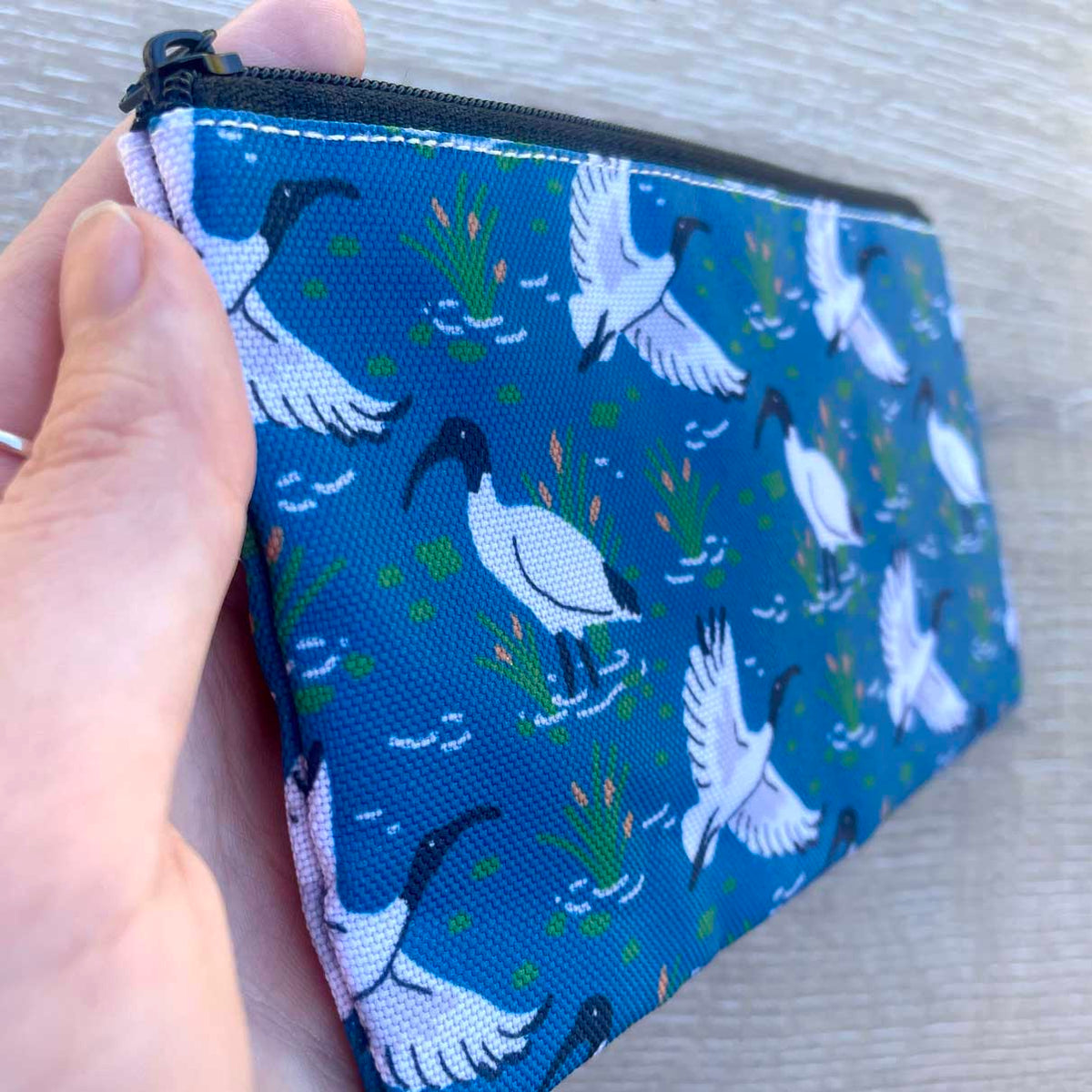 Australian White Ibis wetland pattern pencil case on blue fabric with black zip